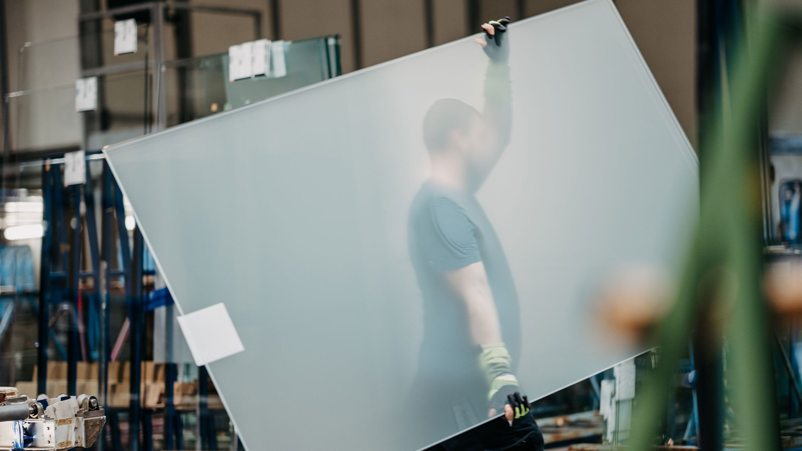 Satinierte Glasscheibe, die von einem Arbeiter getragen wird